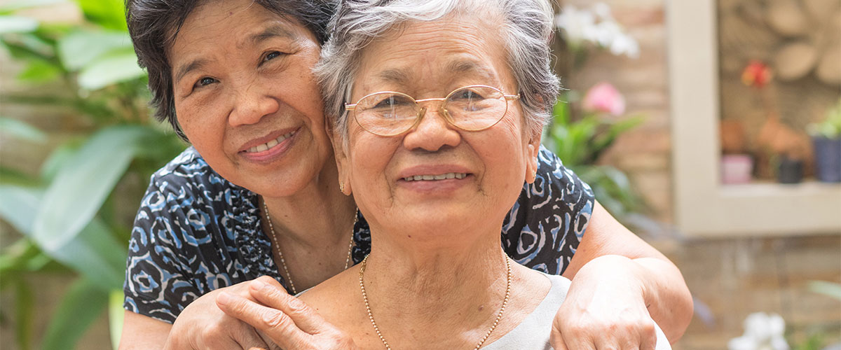 a senior woman posing for a picture with her adult daughter