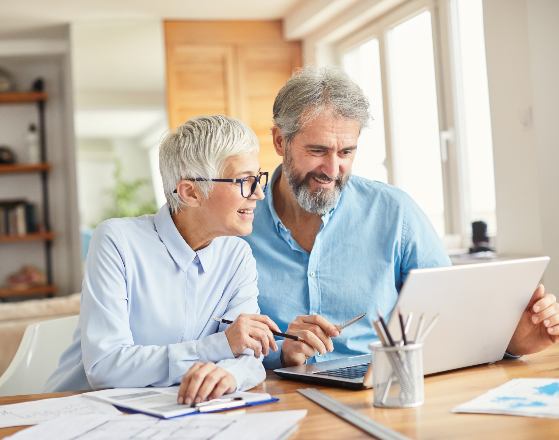 Happy senior couple looking at retirement options on a computer