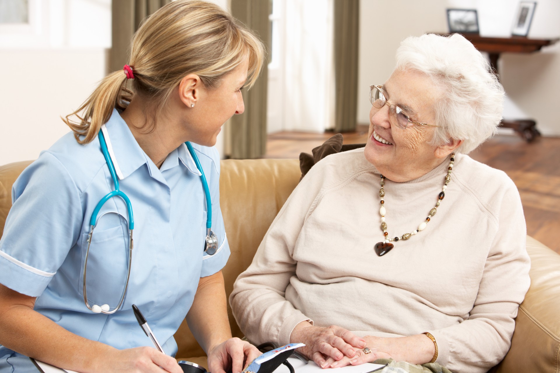 Senior Woman In Discussion With Health Visitor At Home