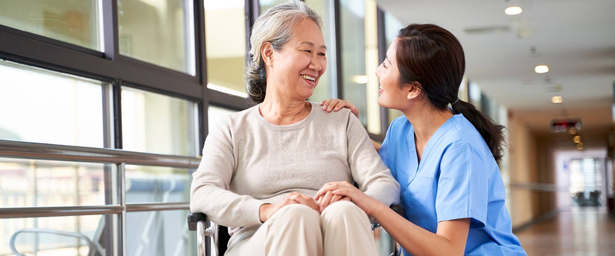senior lady in a wheelchair talking with a health care worker