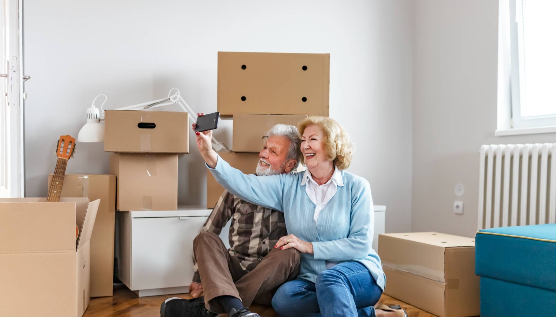 two older adults taking a selfie in their new senior apartment