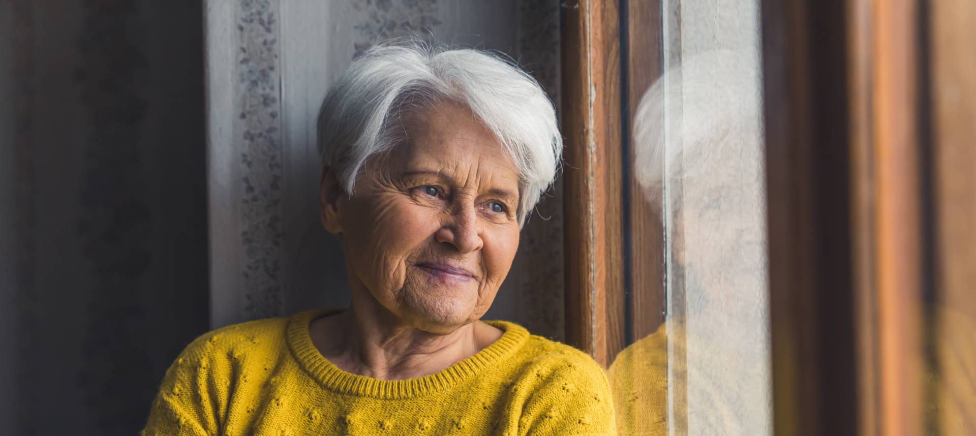 independent senior lady looking out a window