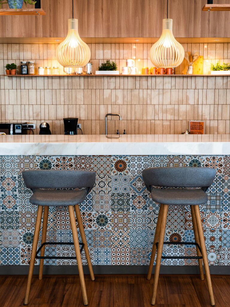 A kitchen with a breakfast bar with tile patters and 70s retro hanging lights